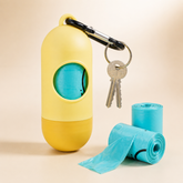 Yellow capsule waste bag holder with clip, keys and blue bags