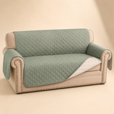 Sage quilted sofa cover draped over a cream loveseat